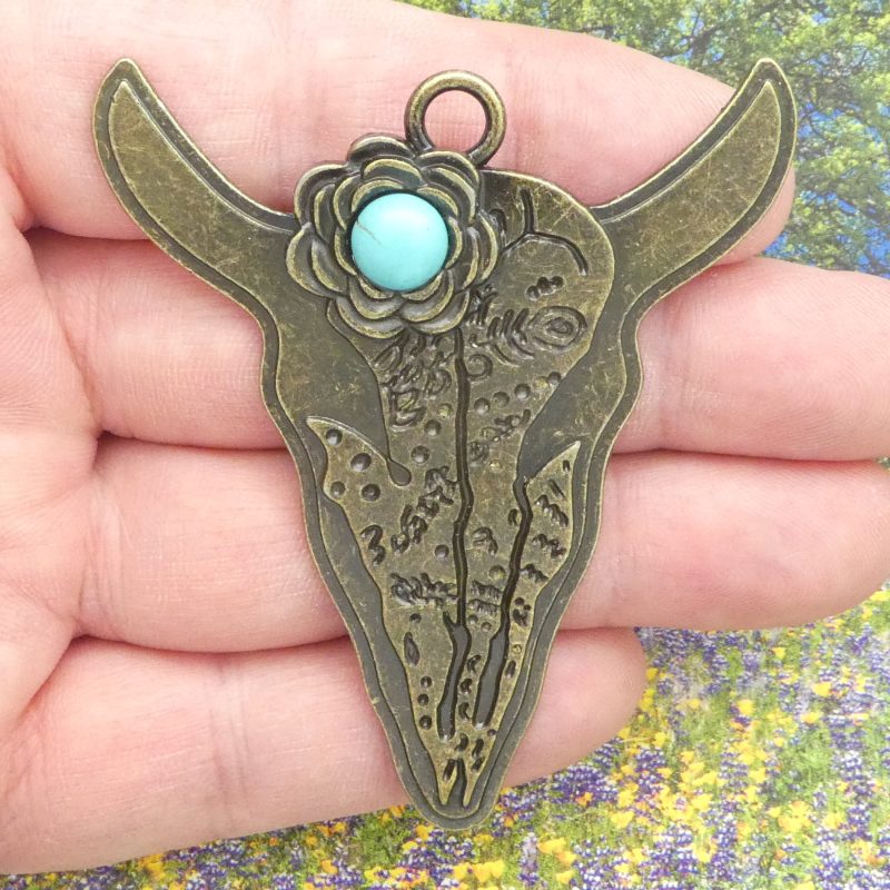 bronze cow skull pendant with turquoise closeup